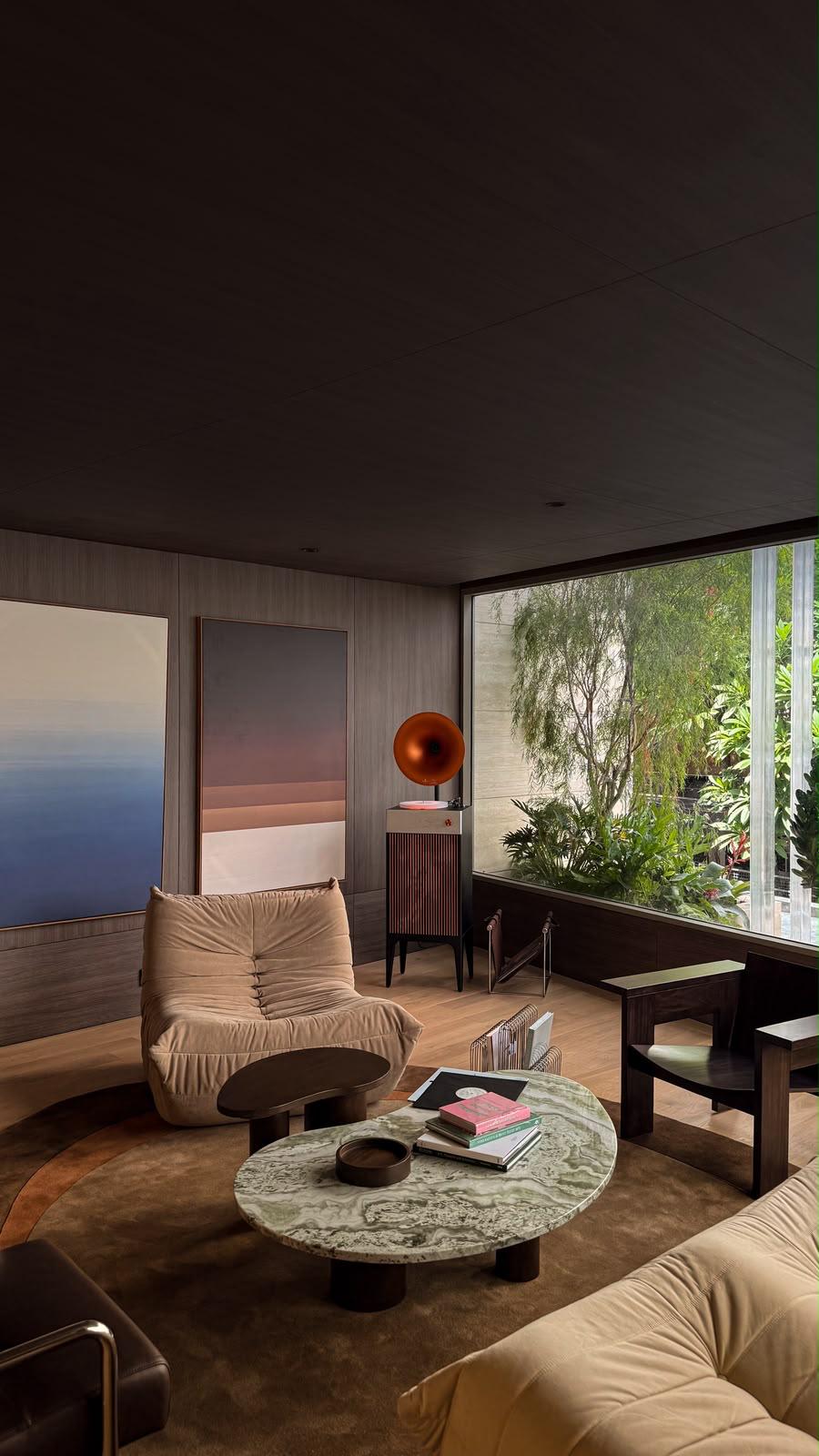 A thoughtfully designed living room with sculptural furniture, art and a garden-facing window
